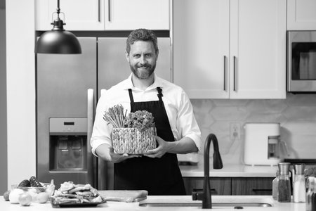 Cooking healthy salad. Chef cooking in apron. Man cook cooking at kitchen. Chef cook man preparing...
