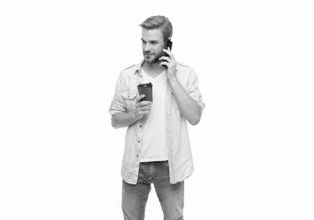 Morning call. Young busy man talking on phone. Millennial man making call on phone isolated on white. Man calling with phone and coffee. Have talking conversation. Coffee break. Communication skillsの写真素材
