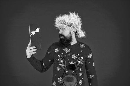 Xmas present and gift. Winter shopping sale. New Year and Christmas. Xmas holiday present. Man at New Year sale. Man hold holiday shopping gift from Santa in studioの写真素材