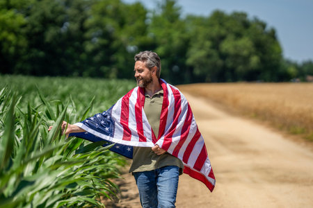 American labor day. American flag and man farmer. Flag of USA. Independence day. Man in field. Man with American flag in crop field. Independence day of America. 4th Julyの写真素材