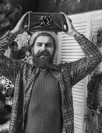 Christmas gift. Happy man celebrate Xmas. Merry Christmas. Santa Claus bearded man. Happy New 2025 Year. Xmas holiday present shopping. Happy Santa man with moustache hold present boxの写真素材