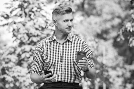 Man texting business message at coffee break. Modern mobile business communication. Businessman messaging on phone. Phone chatting of man. Phone use. Man messaging on phone outdoor. Coffee timeの写真素材