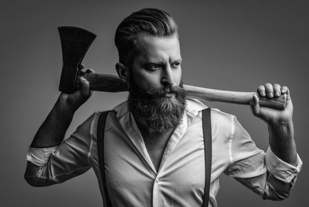 Retro style. Handsome and charismatic. Masculine man. Masculinity of bearded man with axe isolated on grey. Caucasian man with beard and moustache. Masculine energy. Retro barbershopの写真素材