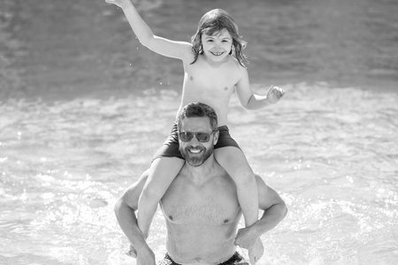 Family bonding of father and son. Family day with dad and son. Father with kid. Fatherhood at summer vacation. Summer vacation at pool. Father son beach adventure. All-inclusive resortの写真素材