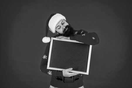 Christmas shopping sale. Happy New Year. Xmas holiday advertisement. Santa Claus man offer New Year sale. Santa man offer holiday shopping. Xmas advertisement, copy space. Sleepy and happyの写真素材