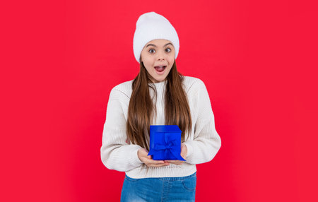 christmas holiday. surprised teen girl with christmas present in studio. teen girlの写真素材