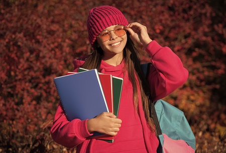 back to school. autumn girl holding school homework. knowledge for adolescence. teen girl in autumn...