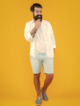 photo of cheerful stylish man with beard. stylish man isolated on yellow. stylish man in studioの写真素材