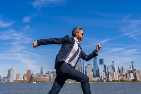 Businessman running to success. Successful deal. Business success. Successful businessman hurrying on New York city skyline. Business man in Manhattan. Business success in big city. Fast pace in cityの写真素材