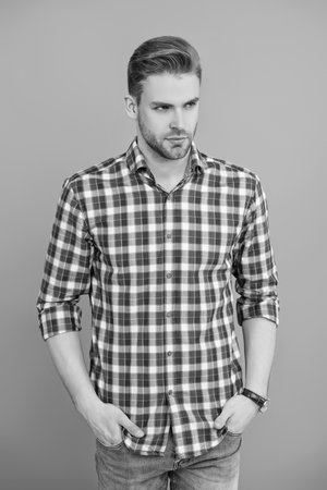 Millennial man wearing checkered shirt. Casual style of millennial man. Portrait of young man in casual style shirt. Stylish face portrait of unshaven guy. Man isolated on grey. Checkered styleの写真素材