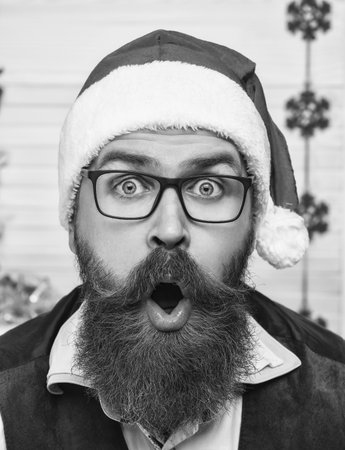 Xmas holiday celebration. Santa man in retro style with moustache. Cozy Christmas at home. Man celebrate Xmas. Merry Christmas. Santa Claus retro man with shocked face. Happy New 2025 Yearの写真素材