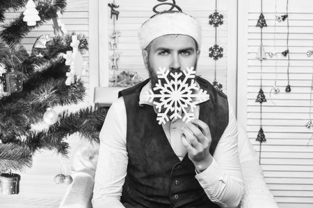 Santa Claus. Man in Santa hat at Christmas. Merry Christmas. New Year holiday. Bearded man with Xmas snowflakes. Happy New 2025 Year. Christmas party decoration. Xmas holiday in winter. Christmas Eveの写真素材