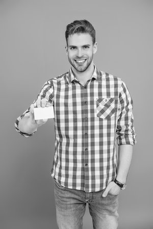 Business man holding a blank card isolated on grey.の写真素材