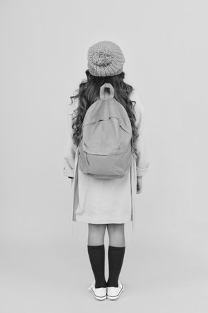 School girl with backpack ready to get education on September 1 knowledge day isolated on yellowの写真素材