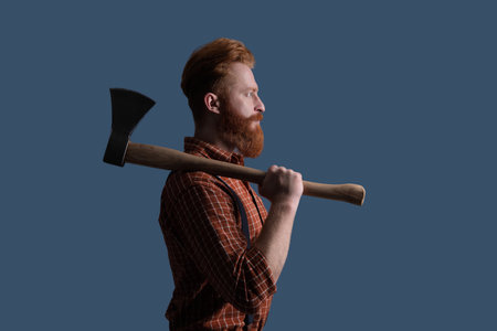 Brutal Caucasian hipster with retro moustache. Bearded man isolated on grey. Bearded man hold ax. Hair and beard care. Handsome bearded brutal man. Beard styling with axe in profileの写真素材