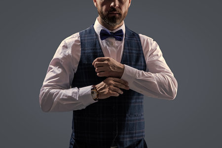 Businessman at formal event. Groom has tuxedo style. Tux of gentleman. Tux suit, cropped. Man with bow tie isolated on grey. Stylish man in elegant black suit. Gentleman in tuxedo vest. Formal wearの写真素材