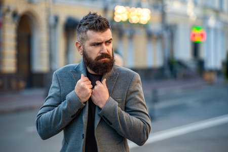 Businessman in business style on street. Business man in urban city. Stylish businessman crossing street, lifestyle. Urban style. City street and stylish man. Bearded man crossing streetの写真素材