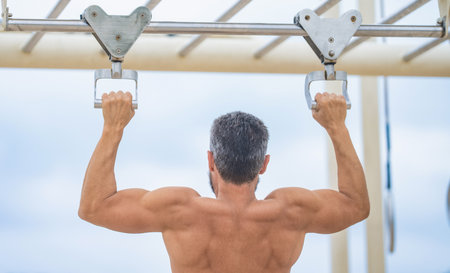 Muscular biceps and triceps. Man pullup. Muscular man sportsman with strong back muscle. Sport...