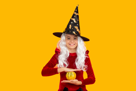 October 31 pumpkin. Costume party. Halloween pumpkin in hand of witch girl. Halloween witch girl...