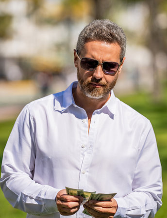 Successful mature man. Millionaire business man with money outdoor. Rich and successful businessman....