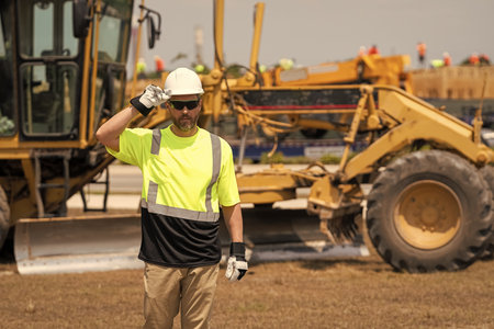 Supervisor engineer. Worker at construction site. Builder man. Worker supervisor at heavy machinery....