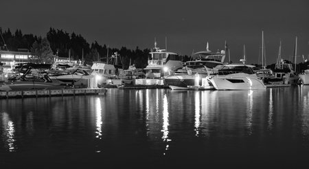 Luxury yacht at night. Night view. Yacht club. Marina in night. Summer vacation. Downtown city marina with luxury illuminated yacht. Docked vessels. Luxury yacht in night marina. Evening yachtingの写真素材