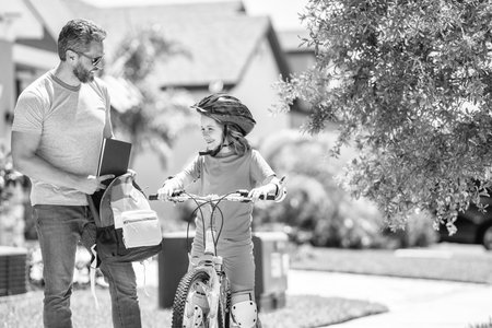 dad guiding his son first bike ride. Pedaling partners. dad and son enjoying fun bike outing. dad and son on biking adventure. dad and son duo pedaling through picturesque landscapeの写真素材