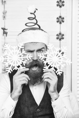 Man in Santa hat at Christmas. Merry Christmas. New Year holiday. Bearded man with Xmas snowflakes. Happy New 2025 Year. Christmas party decoration. Xmas holiday in winter. Amazed Santa Clausの写真素材