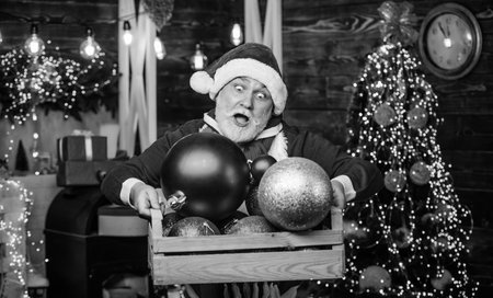 Santa Claus. Mature man with white beard. Christmas spirit. Bearded grandfather senior man celebrate christmas. Kind grandpa with toys. Christmas decoration. Cheerful celebration. Decorating homeの写真素材