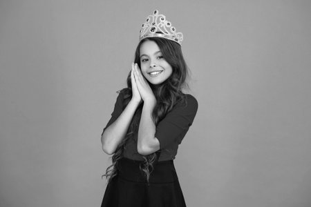 Birthday girl isolated on orange. Teen girl in crown at birthday party. Party celebration. Girlish princess crown. Cute teen girl in princess crown. Party princess cutie. Happy birthdayの写真素材