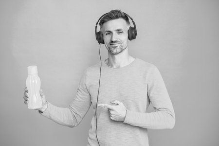 Man hold mineral water. Feel thirsty. Mature man with sport plastic bottle. Healthy lifestyle. Water balance in body. Drinking per day. Hydration vitality. Hydrated thirsty sportsman. Point fingerの写真素材