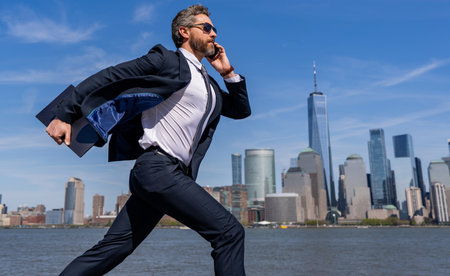 Successful businessman hurrying on New York city skyline. Business man in Manhattan. Business success in big city. Businessman running to success, banner. Successful deal. Business successの写真素材