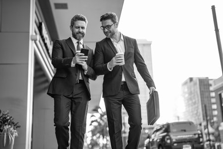 Colleague and friends. Two successful business men walking outdoor. Businessmen go to work. Business talking. Two businessmen in elegant business suit. Walking colleagueの写真素材