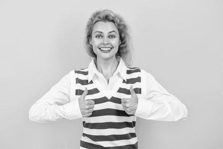 Caucasian young stylish businesswoman. Redhead woman casual style. Casual fashion. Professional business woman corporate leader. Woman manager standing isolated on yellow. Thumb upの写真素材