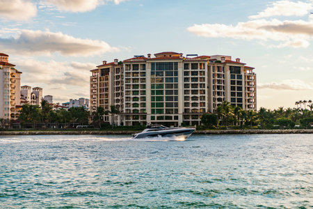 Luxury yacht boat at Fisher island. Summer vacation. Fisher island residential building and luxury yacht boat. Sunset view of Fisher island, Miami. Motor boat yacht floating to marinaの写真素材