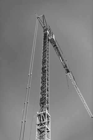 Construction site with building crane. Industrial area. Building and construction. Hoisting crane. Construction at building site with crane. Construction crane at building areaの写真素材