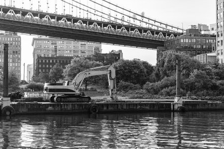 Brooklyn bridge repair with heavy machinery excavator. Construction site and industrial heavy machine excavator. Bridge repair. Excavator digger. Heavy equipment machineryの写真素材