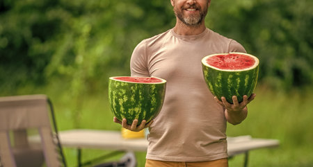 Man with watermelon in summer camping. Man hiker outdoor on summer day. Camp and nature picnic. Man camping. Camp watermelon picnic. Yummy healthy food. Fresh food in camp. Copy spaceの写真素材