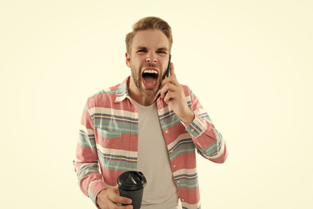 Shouting during phone call. Mobile communication. Communication. Man speak on smartphone isolated on white. Millennial man has phone conversation. Voice mail. Man talk on smartphone with coffeeの写真素材