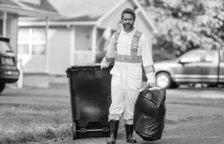 Pollution and recycling. Man putting garbage bag in a trash bin. Environmental protection. Labor day. Picking up garbage plastic for cleaning. Keeping garbage plastic into bag for trash. Save planetの写真素材