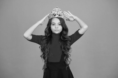 Happy birthday. Birthday girl isolated on orange. Teen girl in crown at birthday party. Party celebration. Girlish princess crown. Cute teen girl in princess crownの写真素材