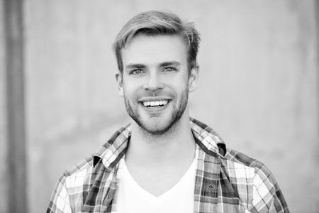 Handsome young man outdoor. Millennial man wearing checkered shirt. Casual style of millennial man. Portrait of man in casual style shirt. Stylish face portrait of cheerful unshaven guyの写真素材