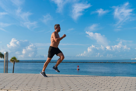 Man running at beach. Healthy lifestyle. Sportsman running in summer. Sport runner do workout. Sport lifestyle with morning run. Runner man bare torso running. Sport and health. Jogging outdoorの写真素材