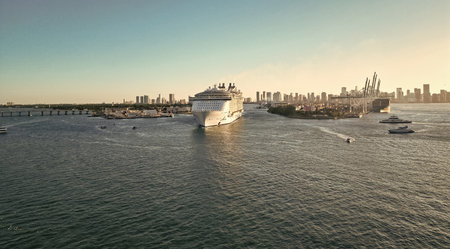 Aerial view of luxury liner voyage. Ship leaving Miami beach port. Miami tour. Cruise ship voyage. Aerial view of cruise in summer vacation. Cruise ship tour and travel at seaの写真素材