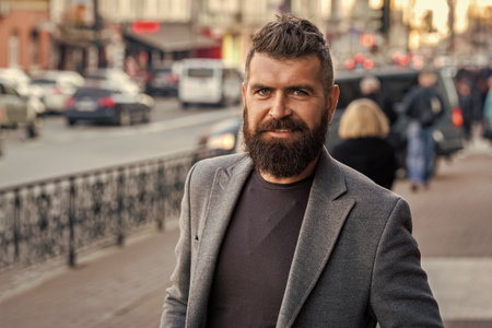 Businessman in business style on street. Business man in urban city. Stylish businessman crossing the street, lifestyle. Urban style. City street and stylish man. Bearded man going to work, bannerの写真素材