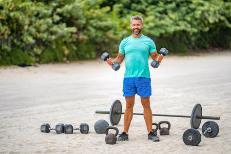 Healthy lifestyle dumbbell training. Strong man exercising with dumbbell outdoor, banner. Man...