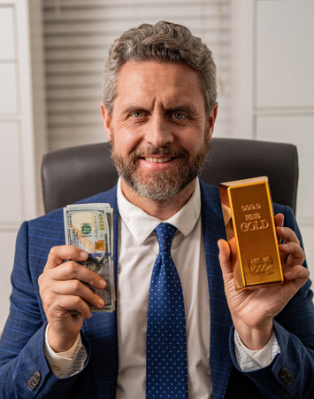 Financial saving success. Successful rich man with gold and money. Business success man with gold bar. Golden bar. Golden bar vs dollar money. Rich Hispanic businessman saving gold and cash moneyの写真素材