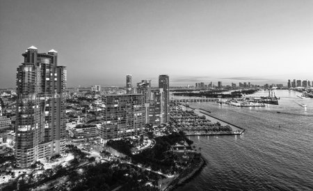 Aerial panoramic view on skyscraper cityscape at night. Night city aerial. Luxury skyscraper in Miami, Florida. City skyline in evening sunset. Aerial waterfront cityscape. Miami South beach at nightの写真素材