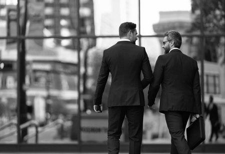 Two businessmen in elegant business suit. Business center. Walking colleague. Colleague and friends. Two successful business men walking outdoor. Businessmen go to work. Business talkingの写真素材