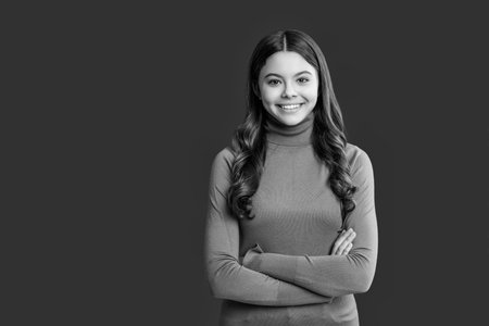 Teen fashion girl portrait. Trendy stylish teen. Fashion style for teen. Portrait of girl has curly hair. Stylish girl in casual sweater. Teen girl wear casual style isolated on red. Copy spaceの写真素材